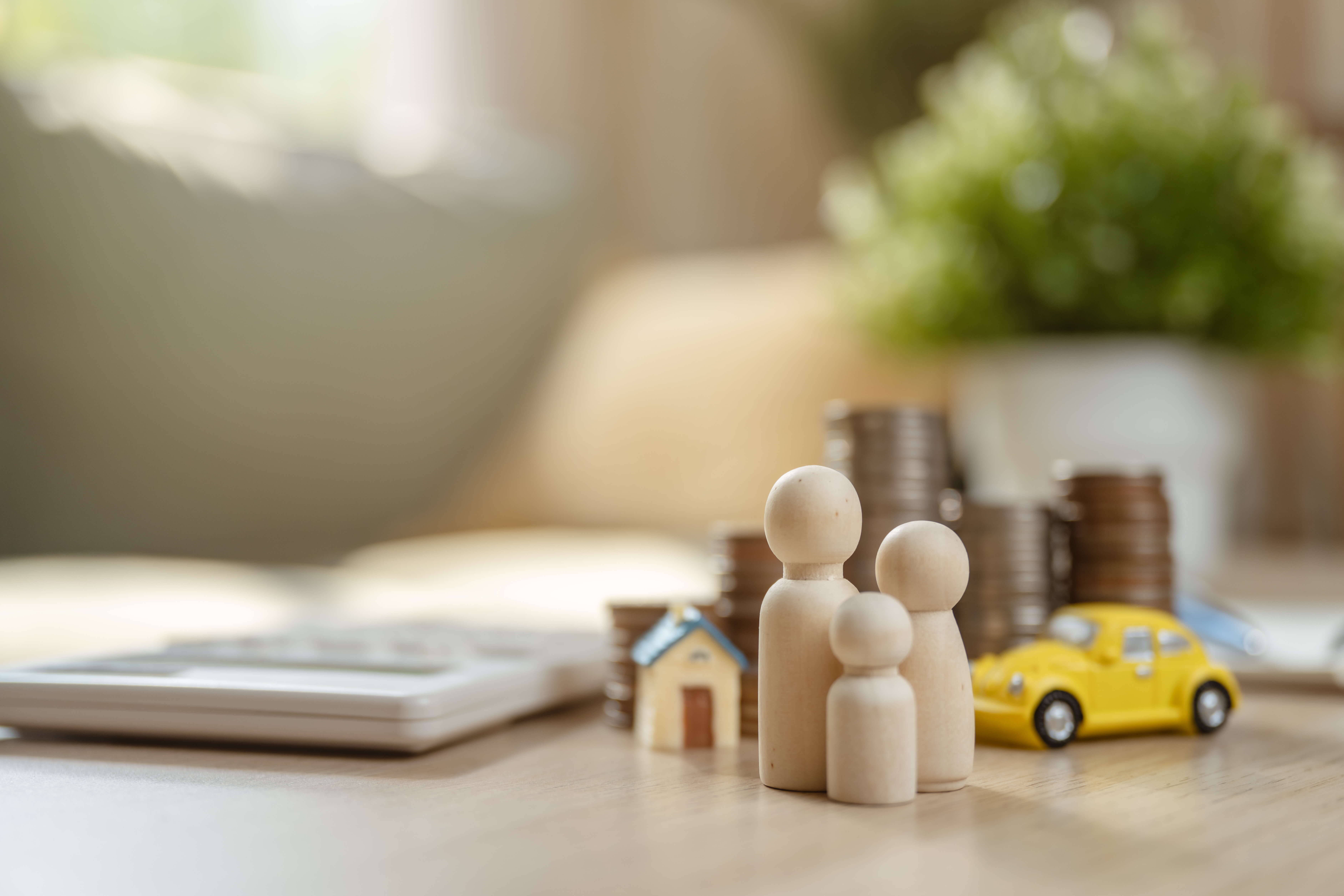 Family financial plan. Finance investment on real estate. Family invest in insurance save plan. A family of three is sitting on a table with a pile of coins and a toy car. Family financial plan. Finance investment on real estate. Family invest in insurance save plan.